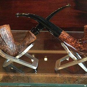 Two traditional wooden tobacco pipes on display stands