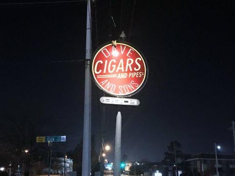 The illuminated Dave and Sons sign on West Markham Street at night